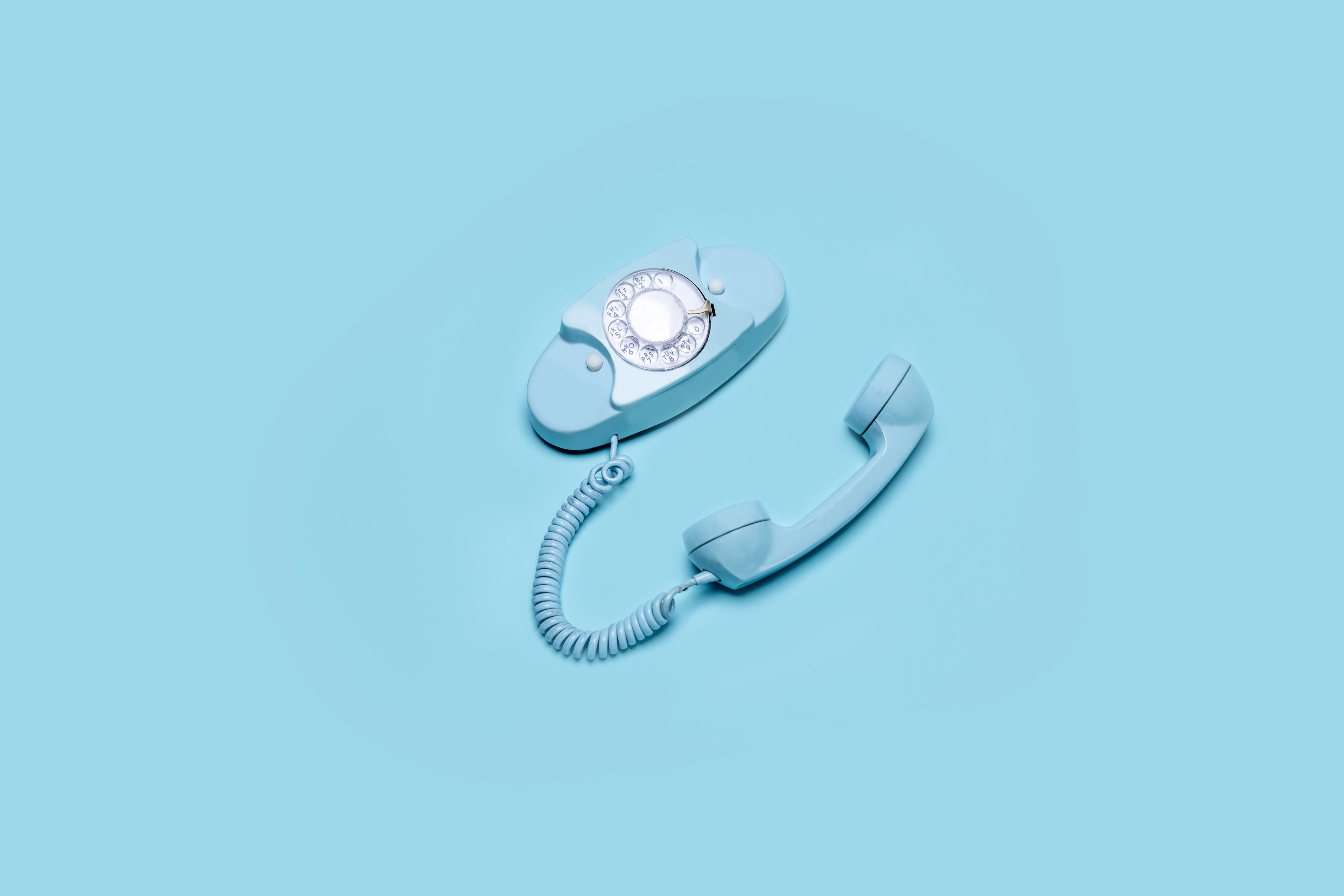vintage-rotary-phone-with-handle-and-cord-laying-beside.jpg